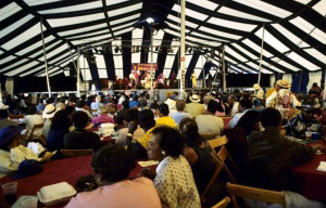 Locals gather around tables under a large tent, looking onwards towards the state, for the 1990 Pythodd Club Reunion